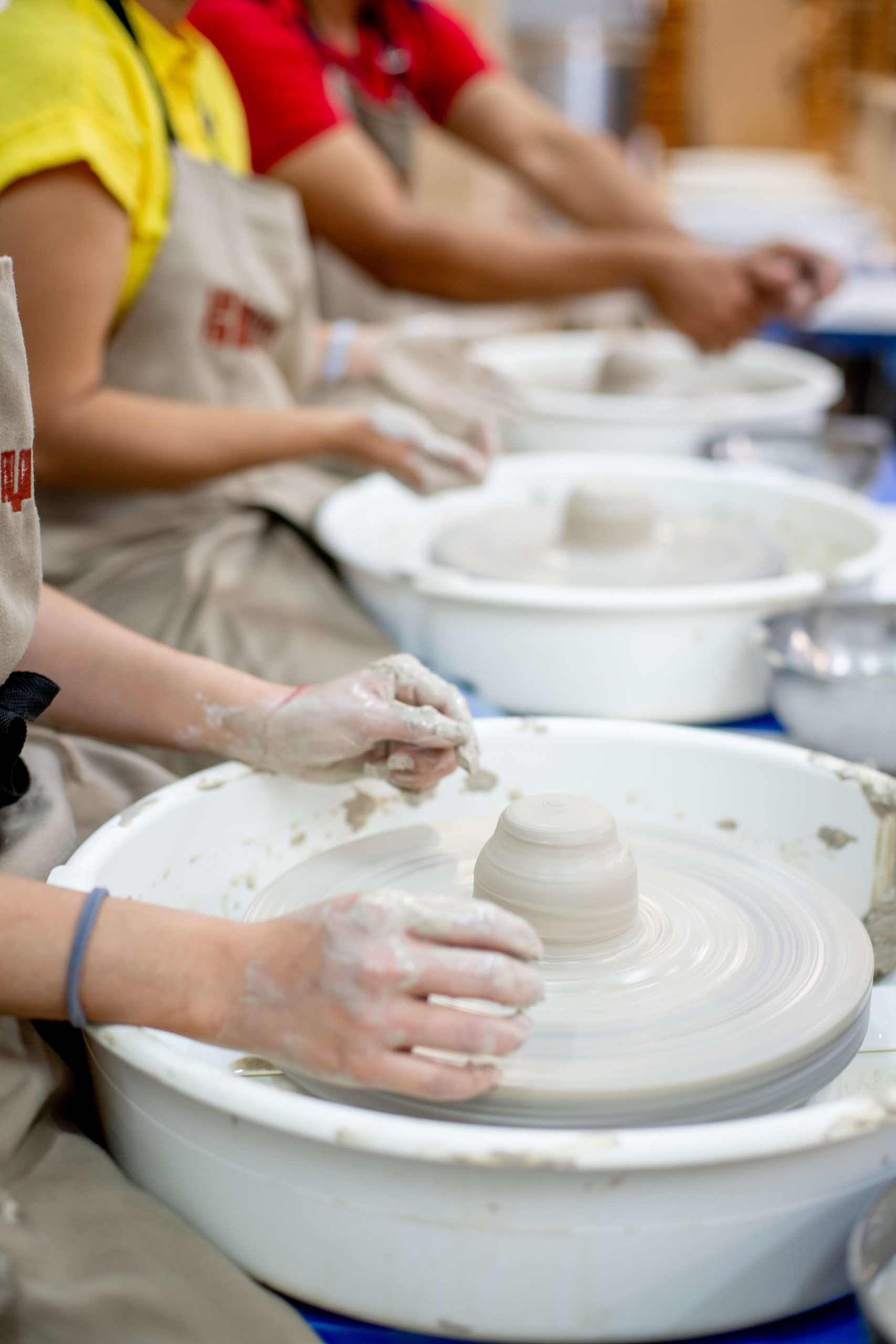 Atelier et cours de poterie chez Klayit avec des élèves façonnant l’argile dans une ambiance chaleureuse. Marie Claire Suisse - Les bonnes adresses
