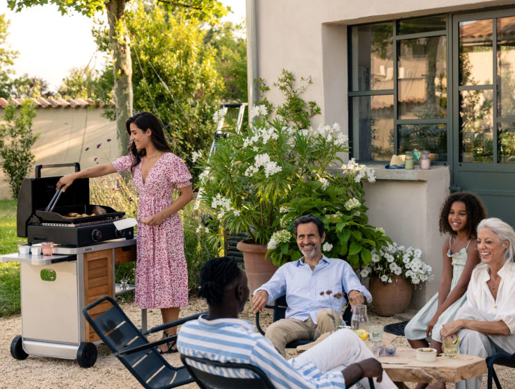 Amis réunis autour d’une plancha Campingaz, en train de cuisiner en plein air