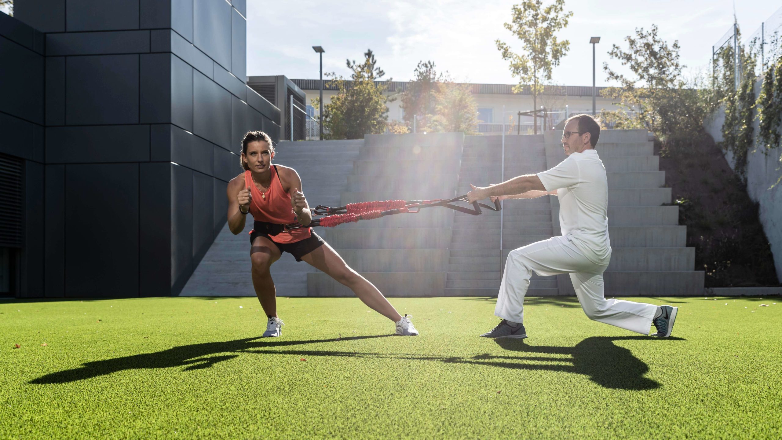 Femme en pleine activité physique dans un cadre sportif, illustrant la pratique adaptée au corps féminin.