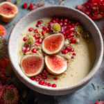 ol de crème parsemé de figues, graines et grenades, entouré de fleurs colorées