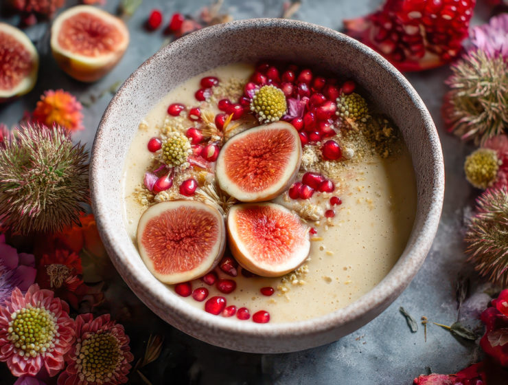 ol de crème parsemé de figues, graines et grenades, entouré de fleurs colorées