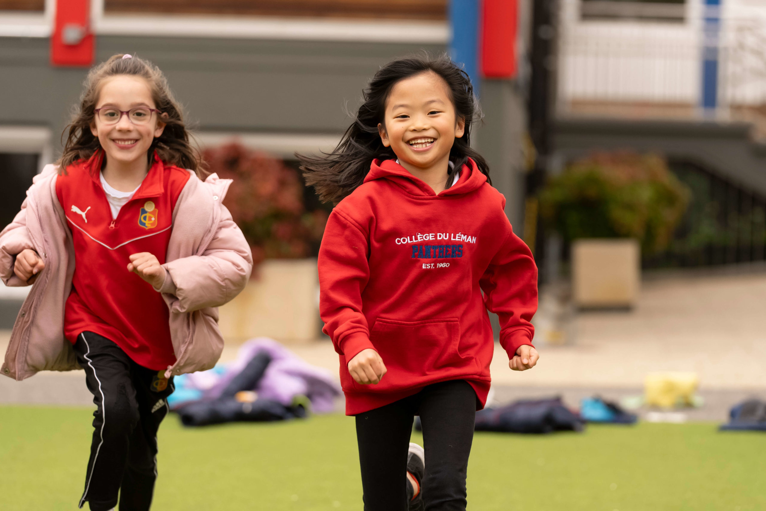 Élèves du primaire courant sur le campus du Collège du Léman à Versoix, école internationale près du lac Léman.