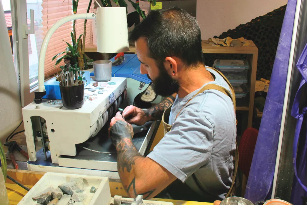François Depraz travaillant une pierre suisse et pendentif artisanal Minera Helvetica.