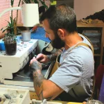 François Depraz travaillant une pierre suisse et pendentif artisanal Minera Helvetica.