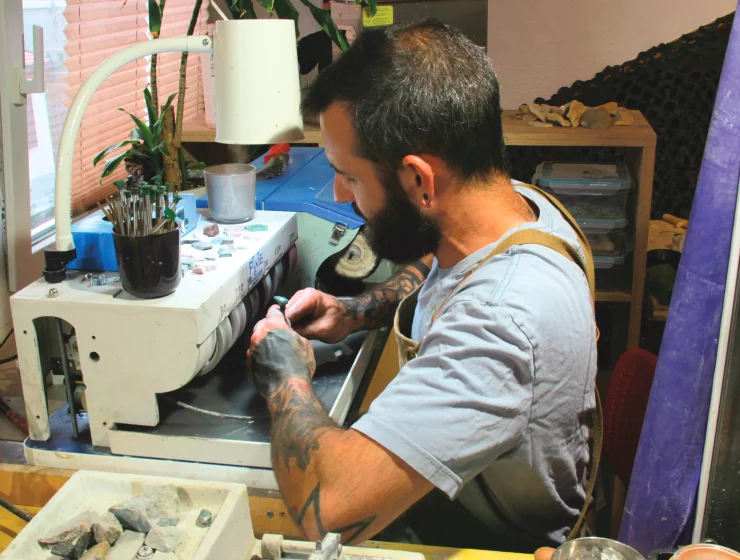 François Depraz travaillant une pierre suisse et pendentif artisanal Minera Helvetica.