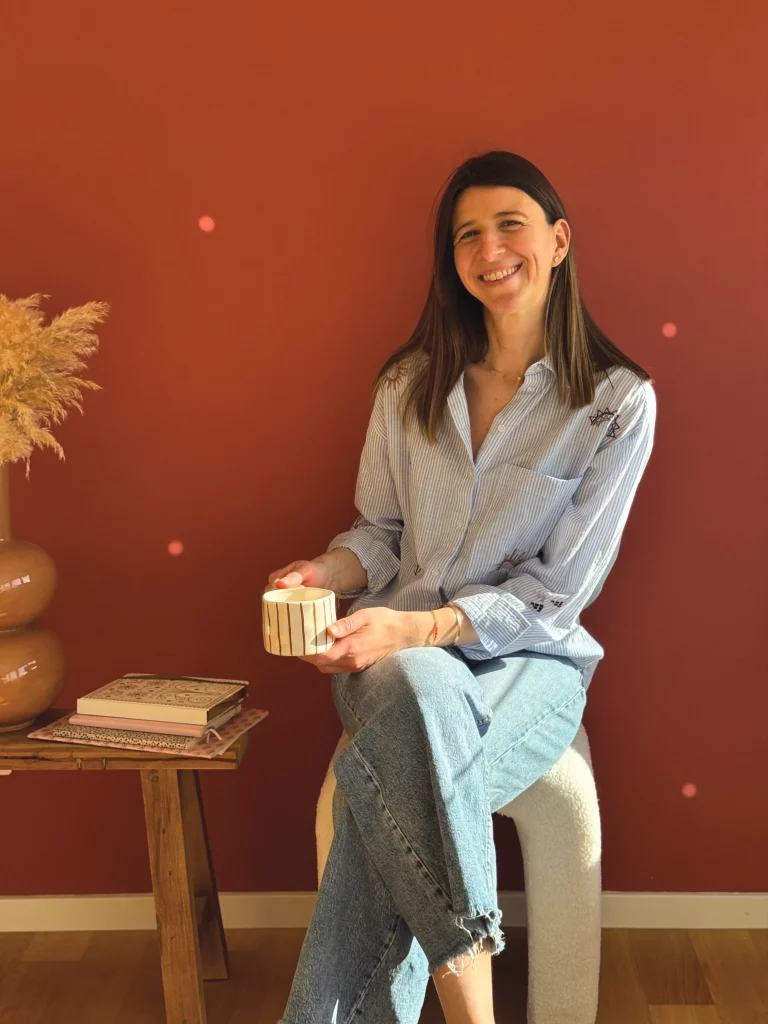 Audrey Toby de Maison Croissance assise avec une tasse dans un intérieur chaleureux.