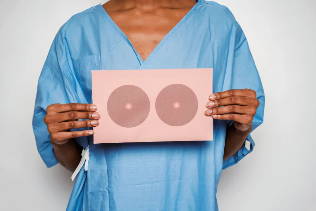 Professionnelle de santé tenant une illustration des seins dans le cadre d’un dossier sur le dépistage précoce du cancer du sein en Suisse.